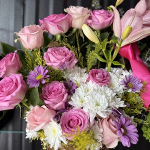 A beautiful basket arrangement with pink roses, lilies, white mums, and lavender daisies. Fresh, full, and perfect for birthdays, quinceañeras, celebrations, and gifting.